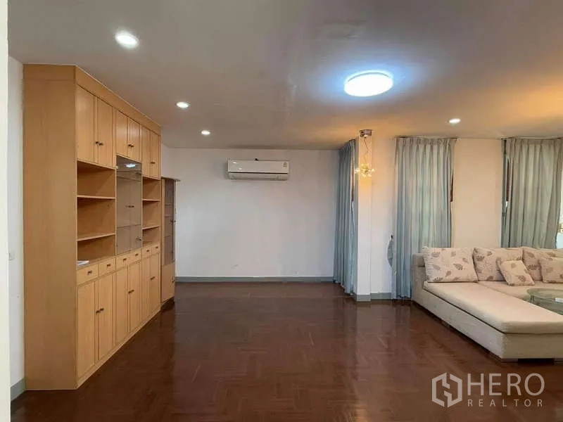 Detached House for rent in Bang Kapi, Bangkok - Living space with built‑in wooden cabinet and wall air conditioner.