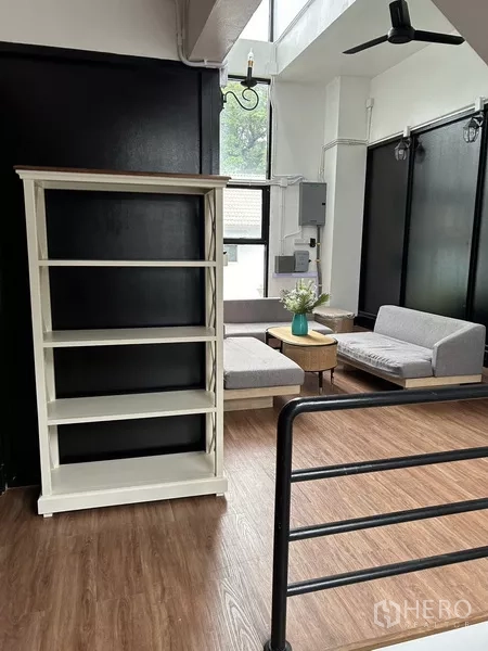 Home Office for rent or sale in Phra Khanong, Bangkok - Open landing with shelving unit, wood flooring and compact seating corner.