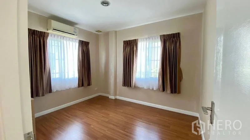 Detached House for rent in Bang Kapi, Bangkok - Bedroom with air conditioning, wood floors and dual windows.