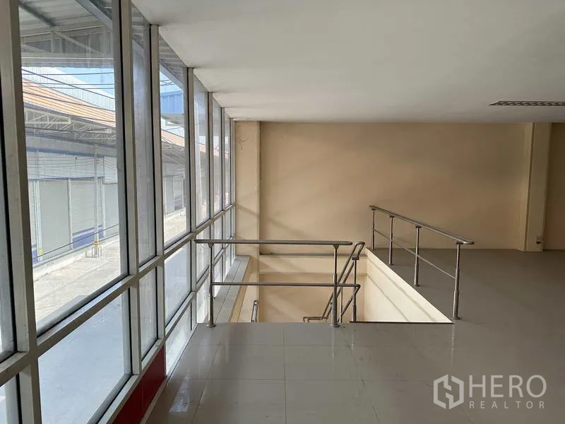 Factory for rent in Bang Phli, Samut Prakan - Mezzanine corridor overlooking the glass facade with stainless handrails and stairwell access.