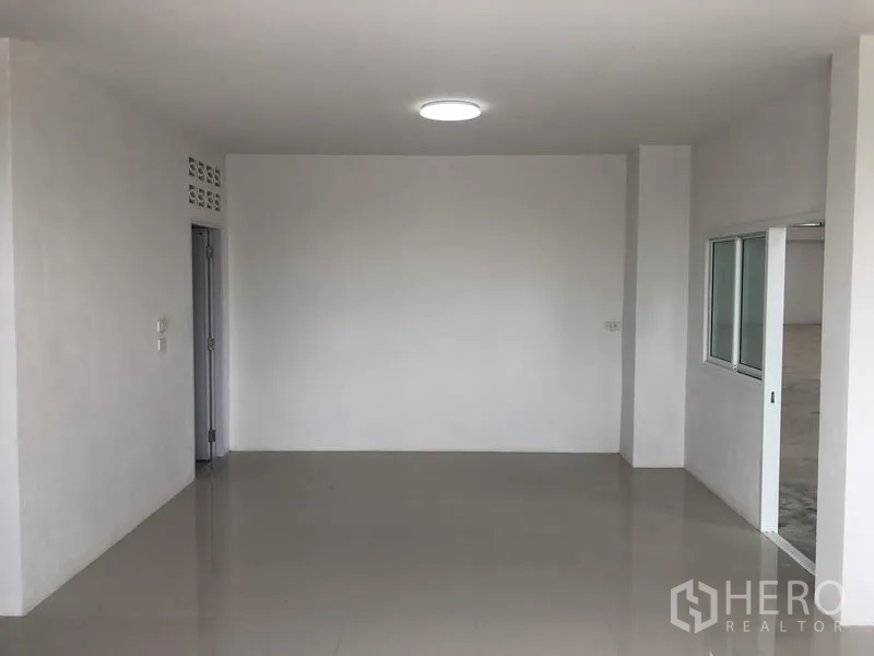 工厂 出租在Sai Noi, Nonthaburi - 开放式办公室区域，亮面瓷砖与吸顶灯，旁接仓库滑窗。