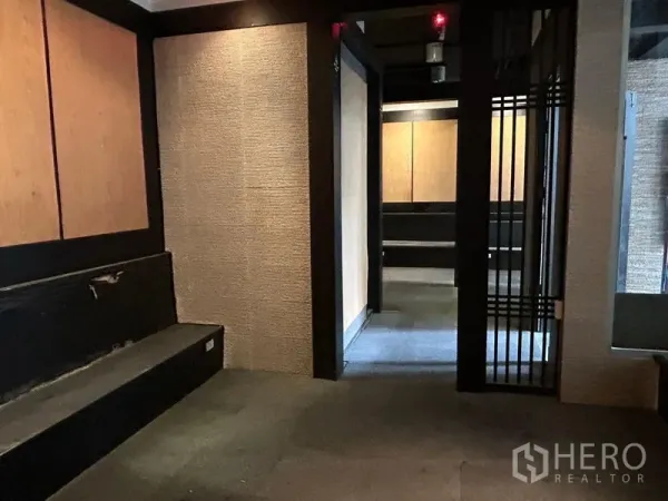 Retail Space for rent in Bang Rak, Bangkok - Cozy room in the retail unit with textured walls, built-in bench seating and a sliding lattice door.