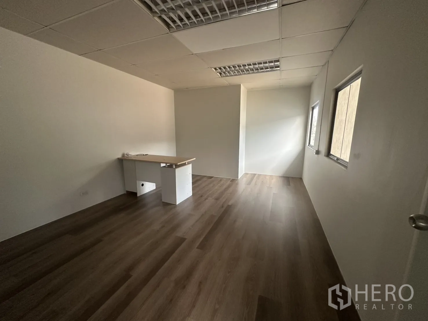 Warehouse for rent in Suan Luang, Bangkok - Large office with drop ceiling lights and wood vinyl flooring.
