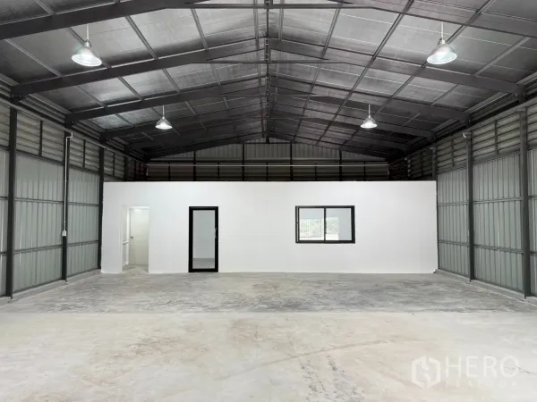 Warehouse for rent in Lat Phrao, Bangkok - Spacious warehouse interior with high insulated roof, built‑in white office room and two restrooms.