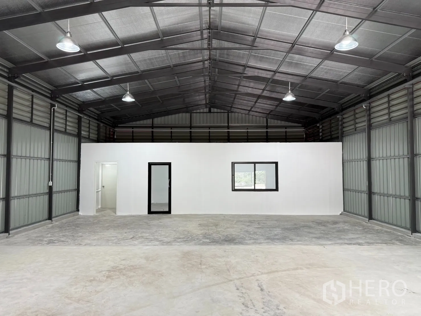 Warehouse for rent in Lat Phrao, Bangkok - Spacious warehouse interior with high insulated roof, built‑in white office room and two restrooms.