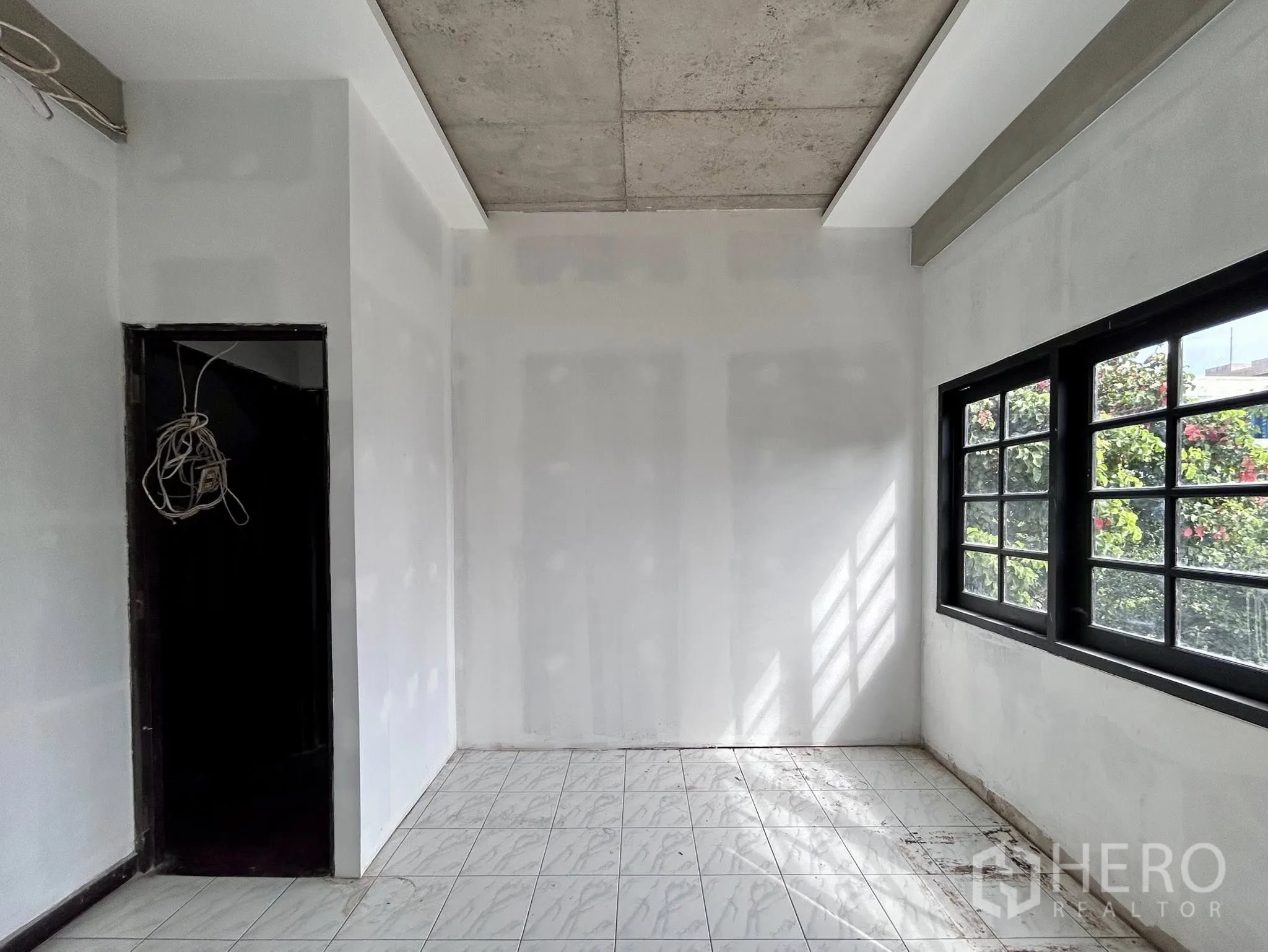 Home Office for rent or sale in Watthana, Bangkok - Bright small room with tiled floor, white walls and black-framed window.