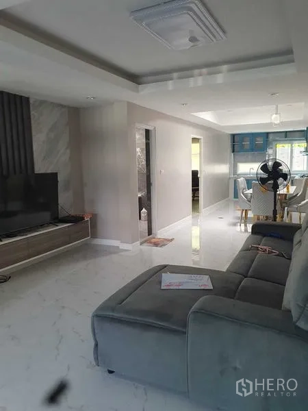 Home Office for rent in Suan Luang, Bangkok - Living area with sofa and TV, opening toward the dining and kitchen zones.