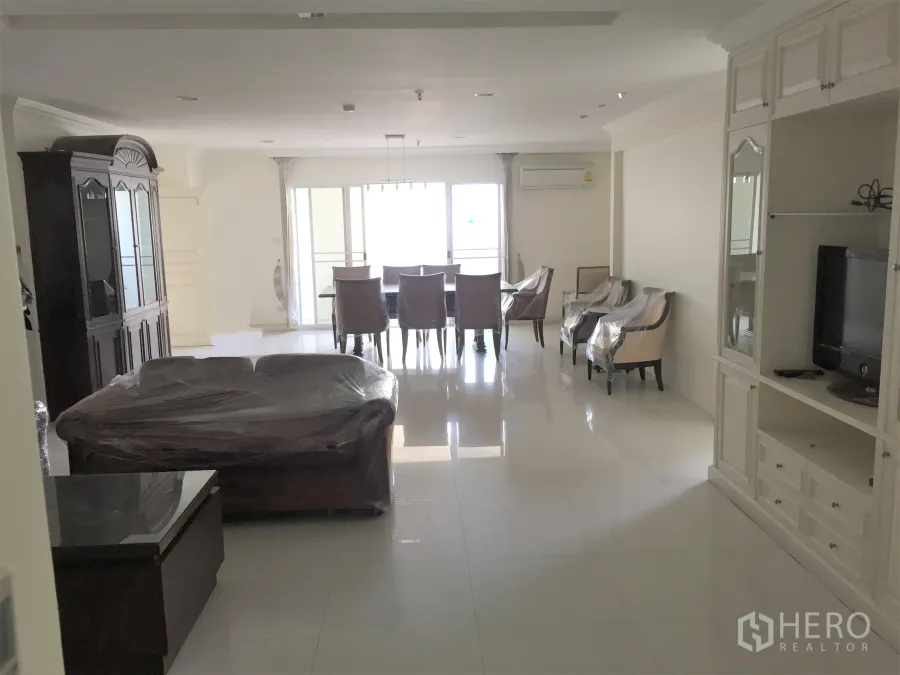 Condominium for rent in Watthana, Bangkok - Spacious living and dining room with large windows, balcony access, and built-in cabinets.