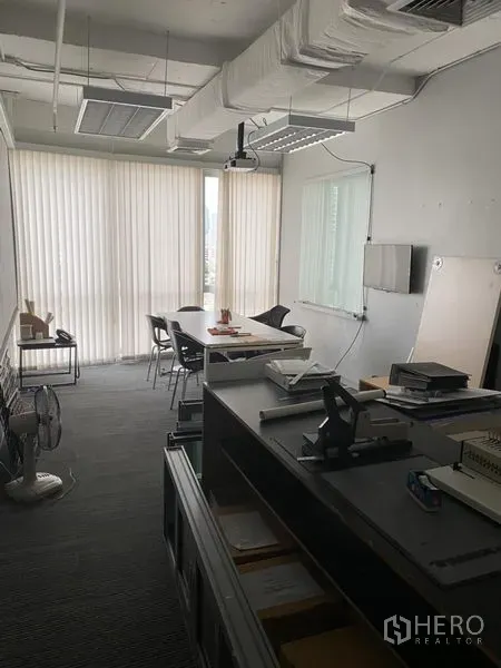 办公空间 出租在Khlong Toei, Bangkok - 独立会议室配长桌、投影与落地百叶窗，可见城市景观。