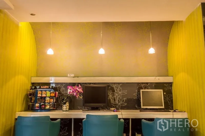 零售空间 出租 - 工作台区域，三盏吊灯、电脑和零食展示架。