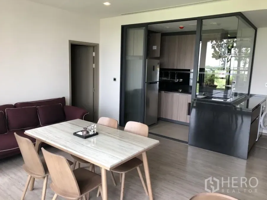 Condominium for rent in Watthana, Bangkok - Open-plan living and dining with a glass-partitioned kitchen and built-in appliances at Mori Haus, Watthana.
