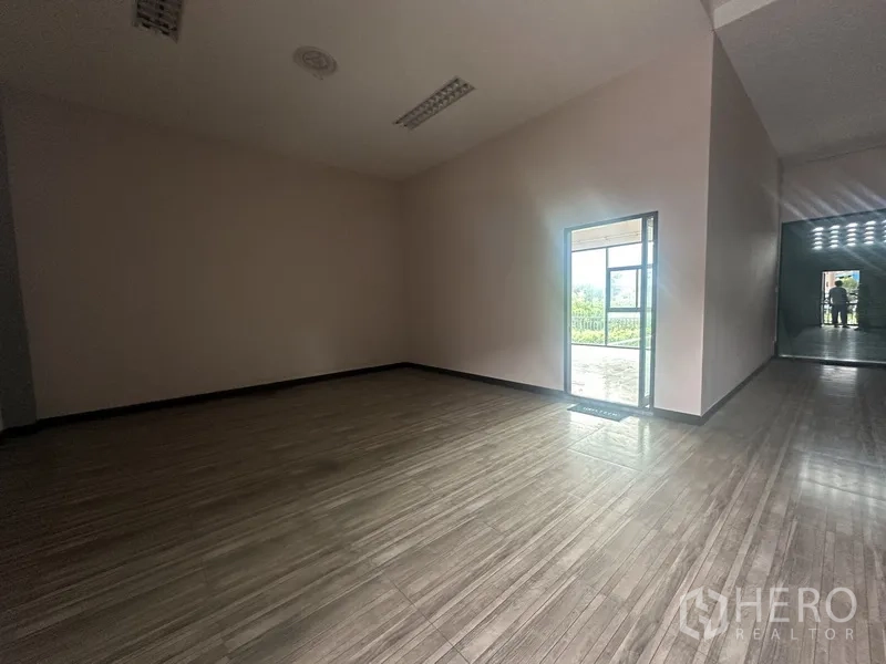 Standalone for rent in Prawet, Bangkok - Empty room with wood-look tile floor and a door leading to the balcony.