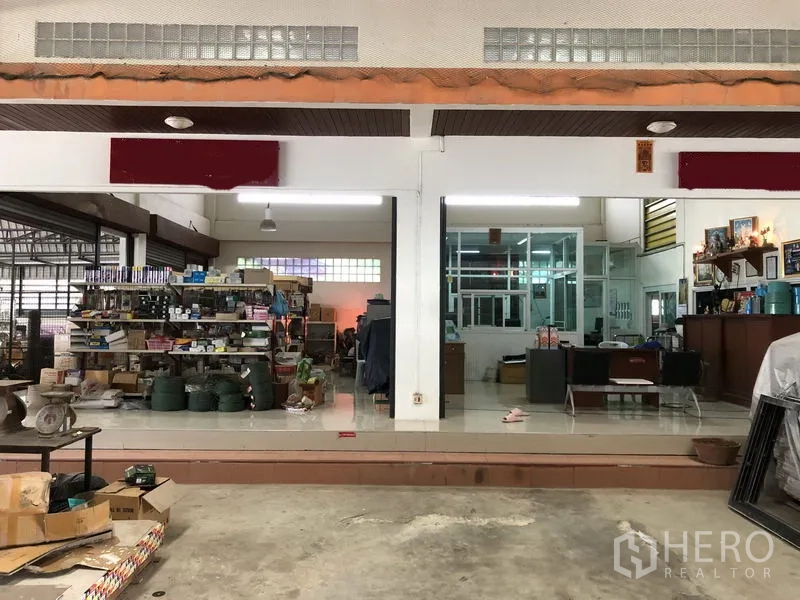 Warehouse for rent in Sai Noi, Nonthaburi - Front office and showroom area inside the warehouse with glass partitions, shelving and tiled floor.