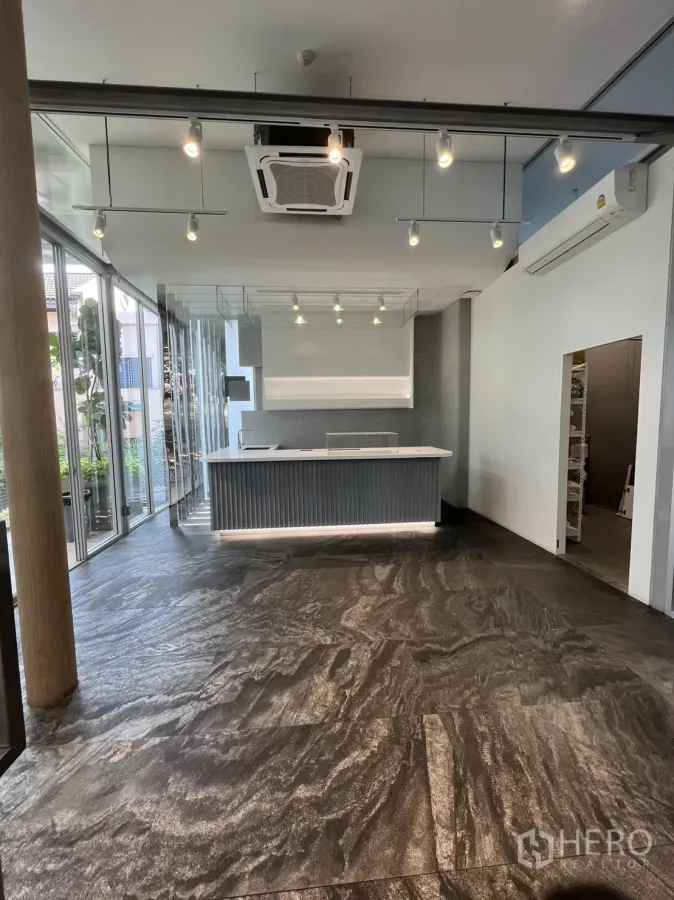 Retail Space for rent in Khlong Toei, Bangkok - Bright retail interior with built-in counter, track lighting, cassette A/C and stone-look flooring beside full-height glass walls in Ekkamai, Bangkok.