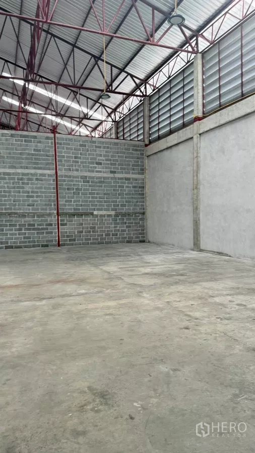 货栈 出租在Min Buri, Bangkok - 仓库开阔角落，高挑屋顶与红色桁架，地面平整。