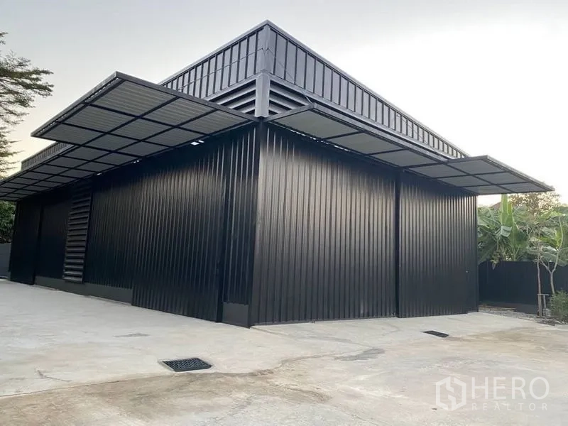 Warehouse for rent in Wang Thonglang, Bangkok - Modern black metal-clad warehouse exterior with large sliding doors and covered loading bays.