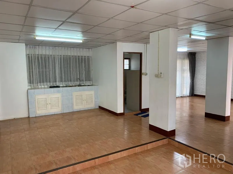 Office Space for rent in Chatuchak, Bangkok - Open office floor with raised platform, pantry counter and doorway to restroom.