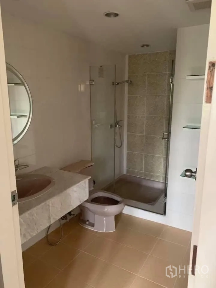 Townhouse for rent in Watthana, Bangkok - Bathroom featuring a glass-enclosed shower, vanity and toilet.