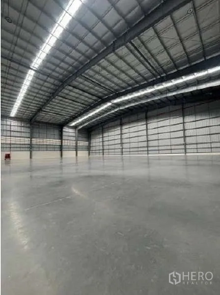 Warehouse for rent in Mueang Rayong, Rayong - Spacious warehouse interior with high steel roof, skylight strips and polished concrete floor.