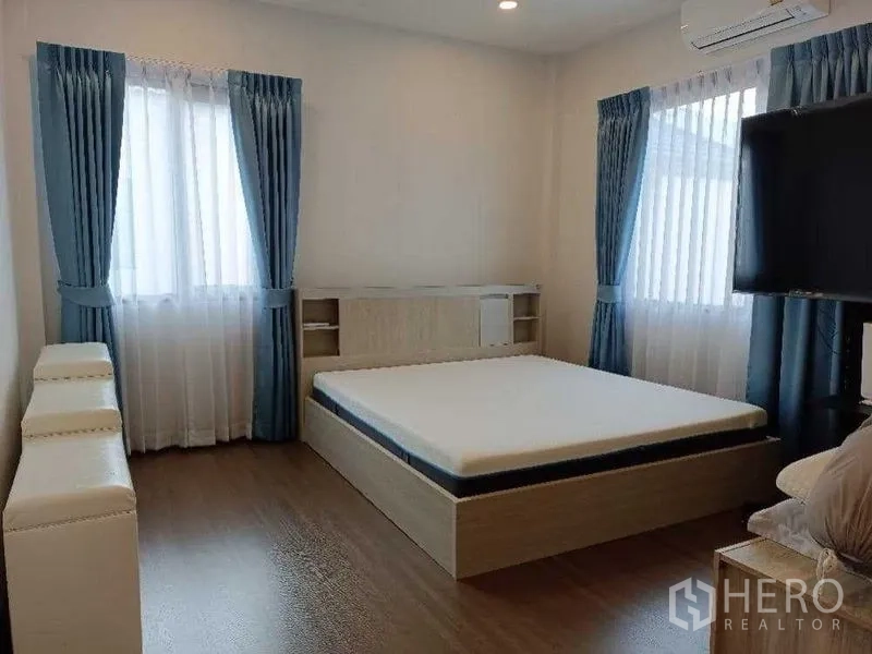 独立式住宅 出租在Mueang Nonthaburi, Nonthaburi - 通透主卧，带电视、大窗与蓝色窗帘。