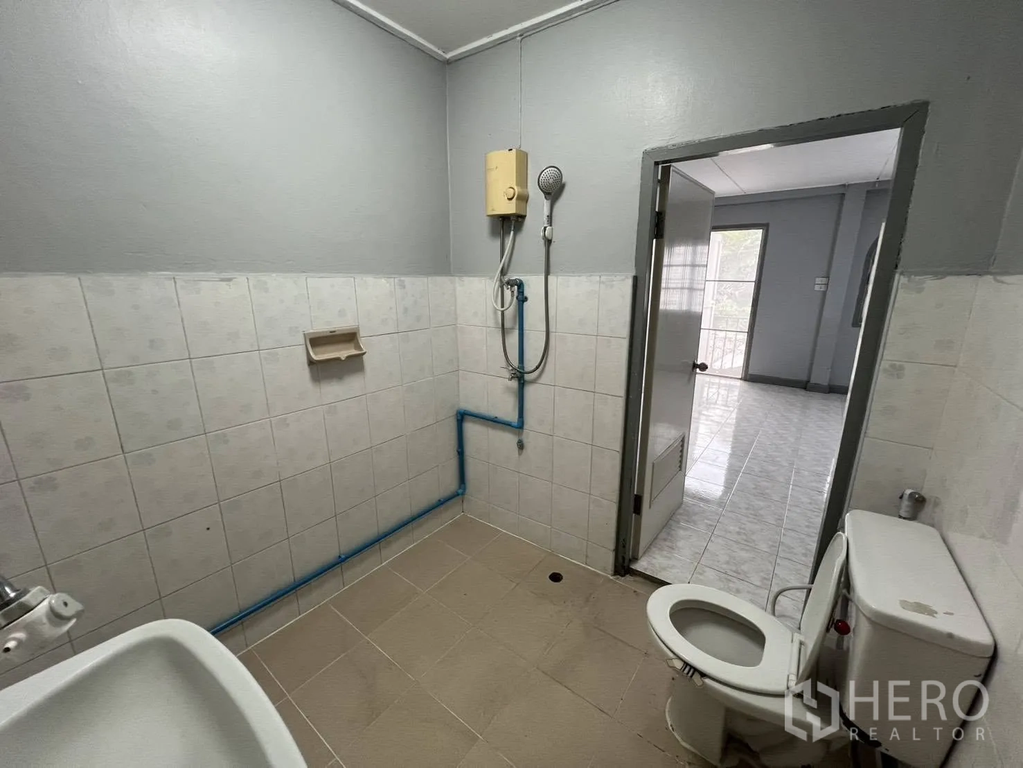 Townhouse for rent in Watthana, Bangkok - Bathroom with showerhead, water heater, toilet and tiled walls.