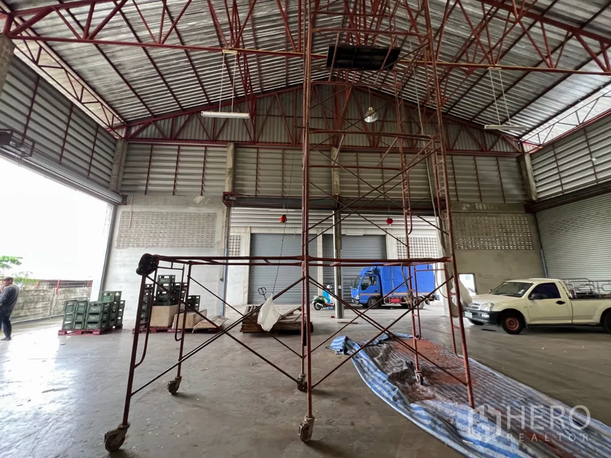 货栈 出租在Khlong Sam Wa, Bangkok - 开阔仓储地面，移动脚手架与大型装卸门，可进出卡车。
