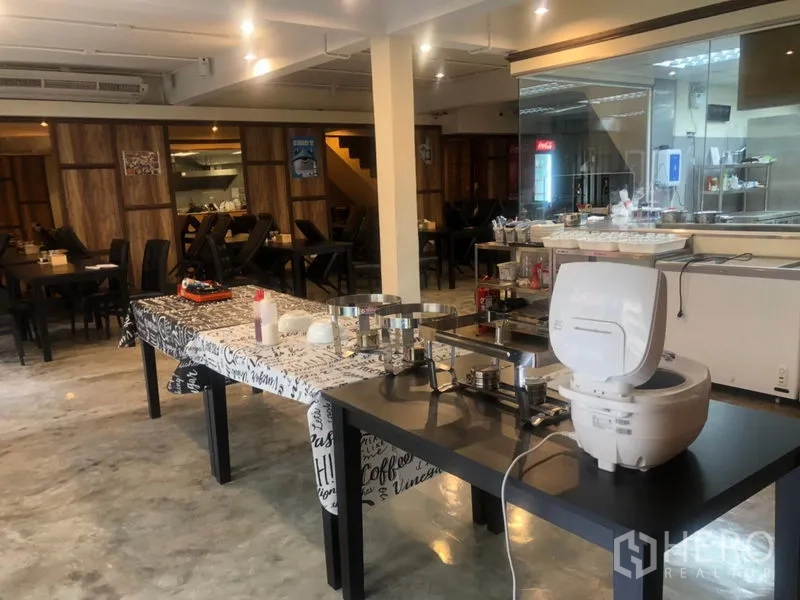 Shophouse for rent in Watthana, Bangkok - Large restaurant floor with buffet setup, open kitchen behind glass and multiple dining tables.
