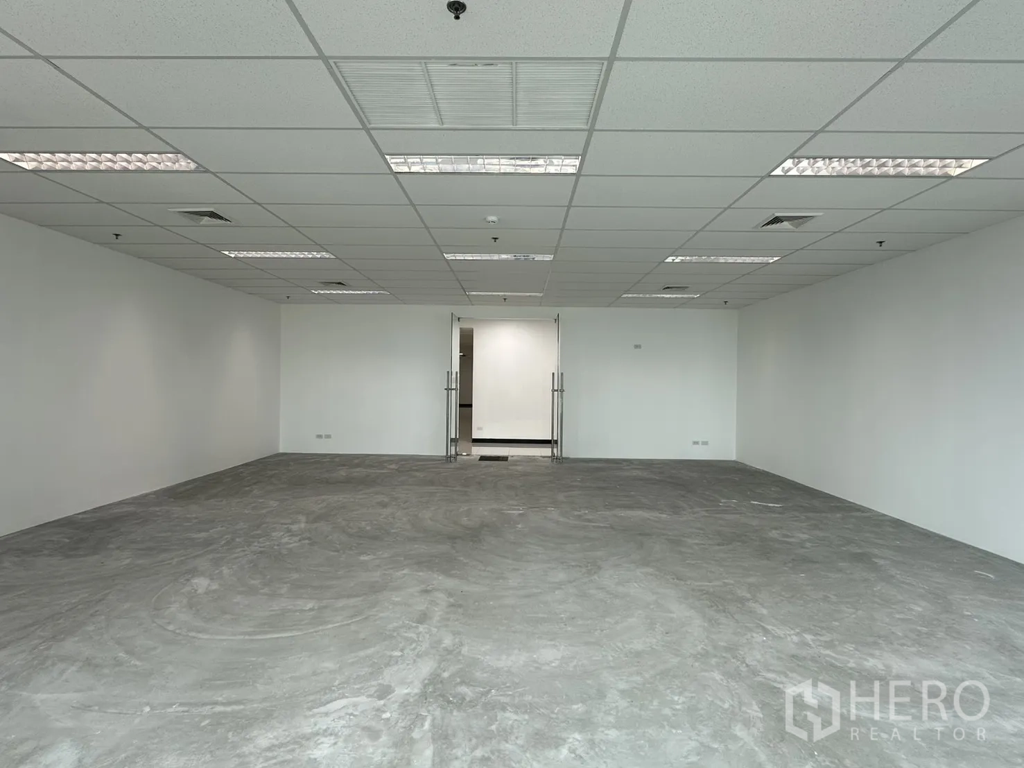 Office Space for rent in Watthana, Bangkok - Open workspace facing double glass doors with lighting panels and polished concrete floor.