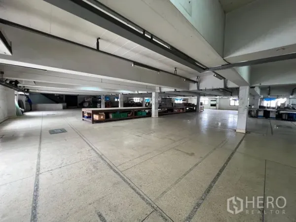 货栈 出租在Bang Kapi, Bangkok - 开阔的仓库楼层，混凝土地面、立柱与条形照明，适合仓储与装配。