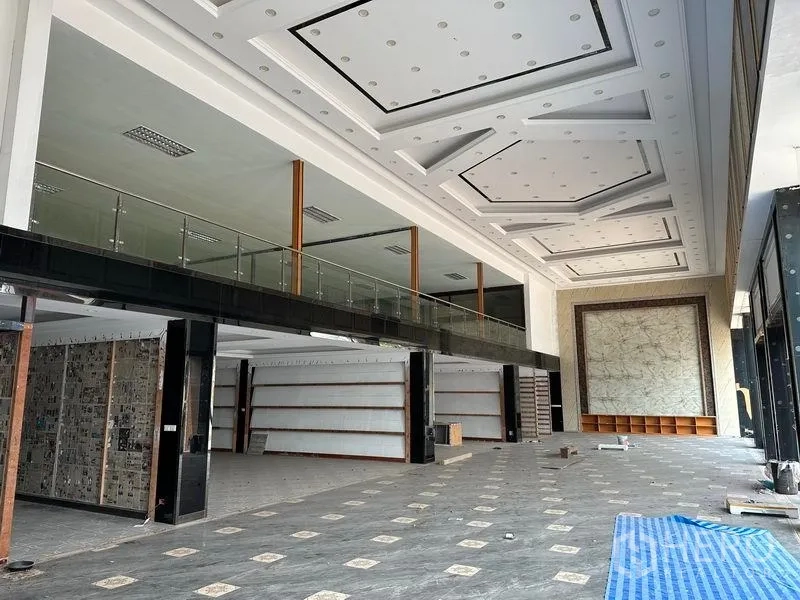 货栈 出租在Lam Luk Ka, Pathum Thani - 双层挑高展厅，方格吊顶、玻璃夹层和瓷砖地面。