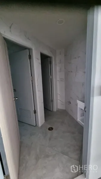 Shophouse for rent in Khlong Toei, Bangkok - Newly tiled restroom corridor with light marble-effect walls and doors.