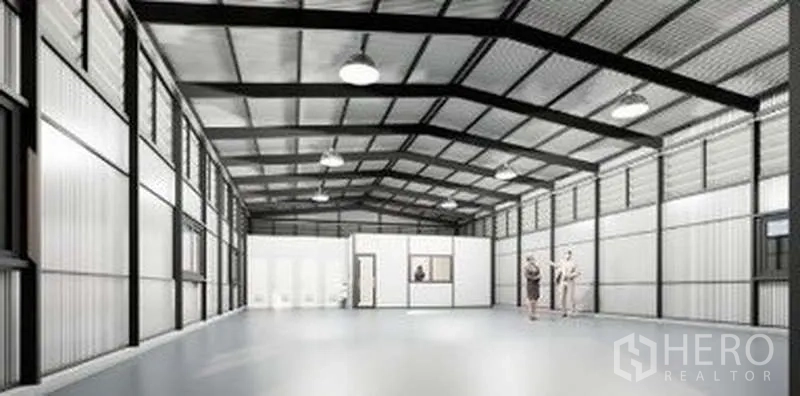 Warehouse for rent in Lat Phrao, Bangkok - Open-plan storage hall with built-in office rooms, restrooms, side windows and a polished concrete floor.