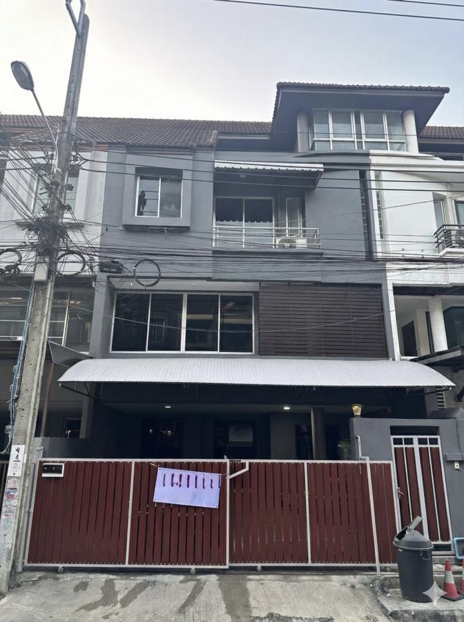 Home Office for rent in Wang Thonglang, Bangkok - Three-storey home office facade with red sliding gate, metal awning and balconies.