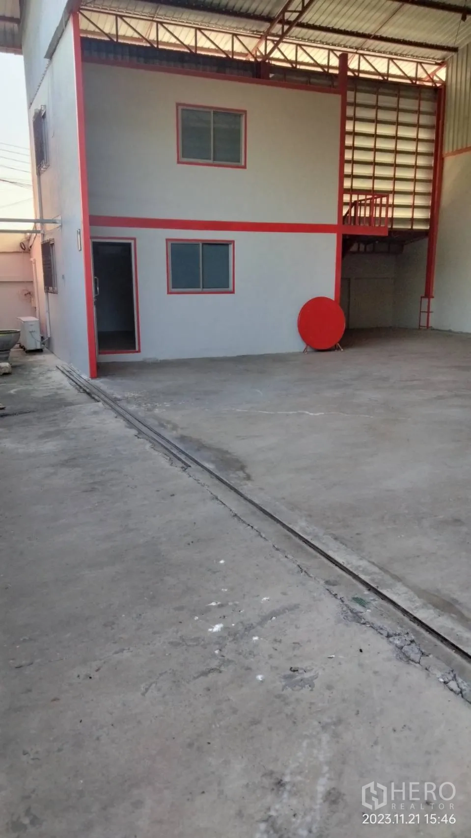Warehouse for rent in Bang Phli, Samut Prakan - Concrete loading yard beside a two-storey office attached to the warehouse.