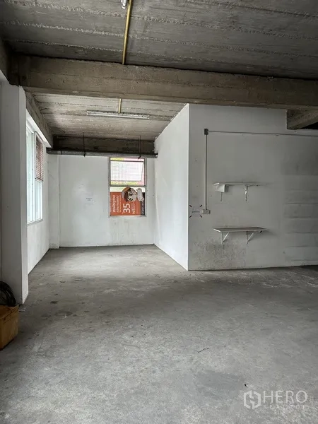 Retail Space for rent in Khlong Toei, Bangkok - Unfinished workspace with concrete floor, white walls and wall-mounted shelves.