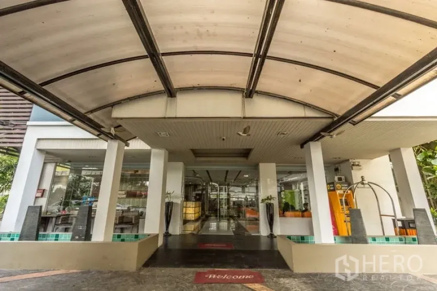 店屋 出租或出售在Khlong Toei, Bangkok - 雨棚覆盖的落客区，通向建筑的玻璃入口。