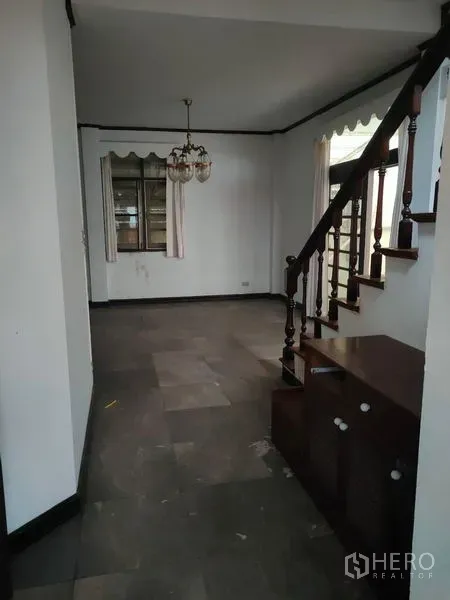 Home Office for rent in Pathum Wan, Bangkok - Open living area with wood staircase, chandelier and tiled flooring.