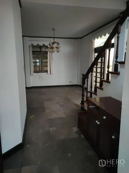 Home Office for rent in Pathum Wan, Bangkok - Open living area with wood staircase, chandelier and tiled flooring.