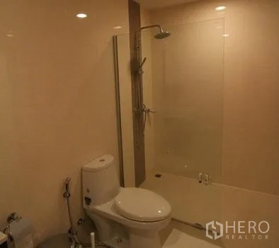 Condominium for rent in Pathum Wan, Bangkok - Clean bathroom with glass-enclosed shower and toilet.