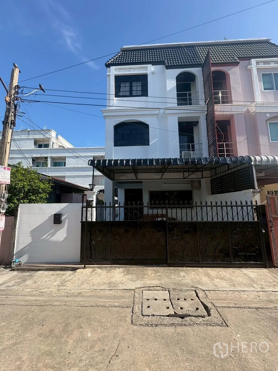 Townhouse for rent in Huai Khwang, Bangkok - Three-storey townhouse exterior with gated front and awning.