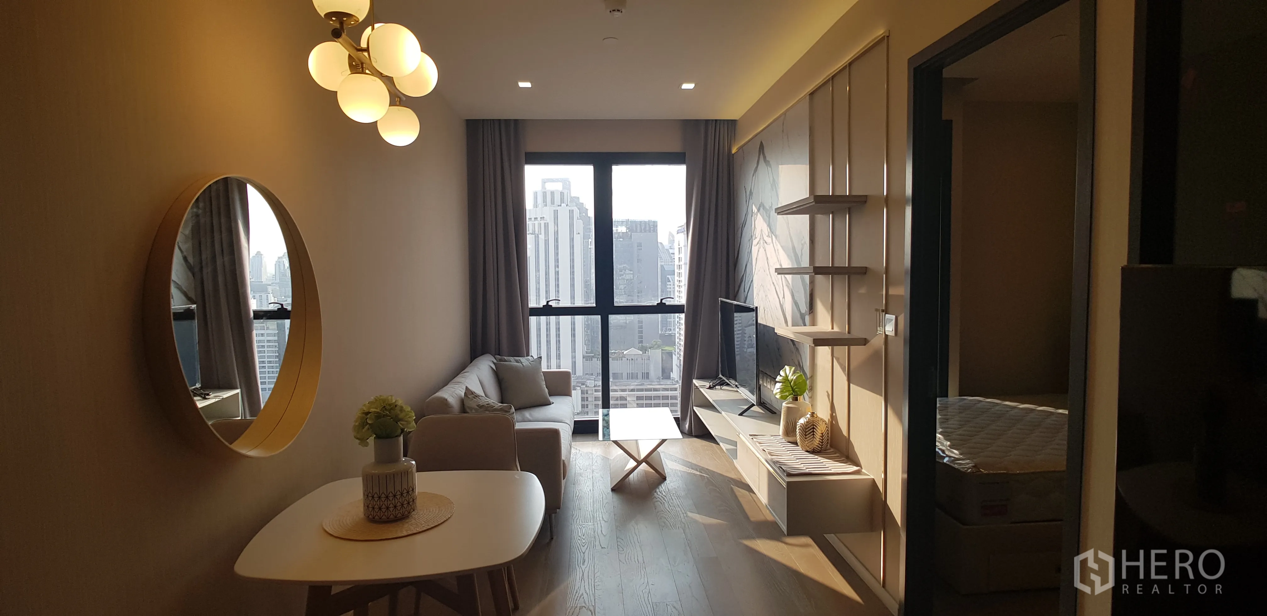 公寓 for rent in Watthana, Bangkok - 明亮客厅，沙发与电视墙，落地窗可观赏曼谷天际线。