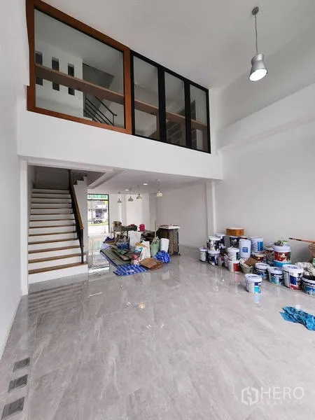 货栈 出租在Phra Khanong, Bangkok - 底层展示/装卸区，挑高空间，夹层玻璃与楼梯