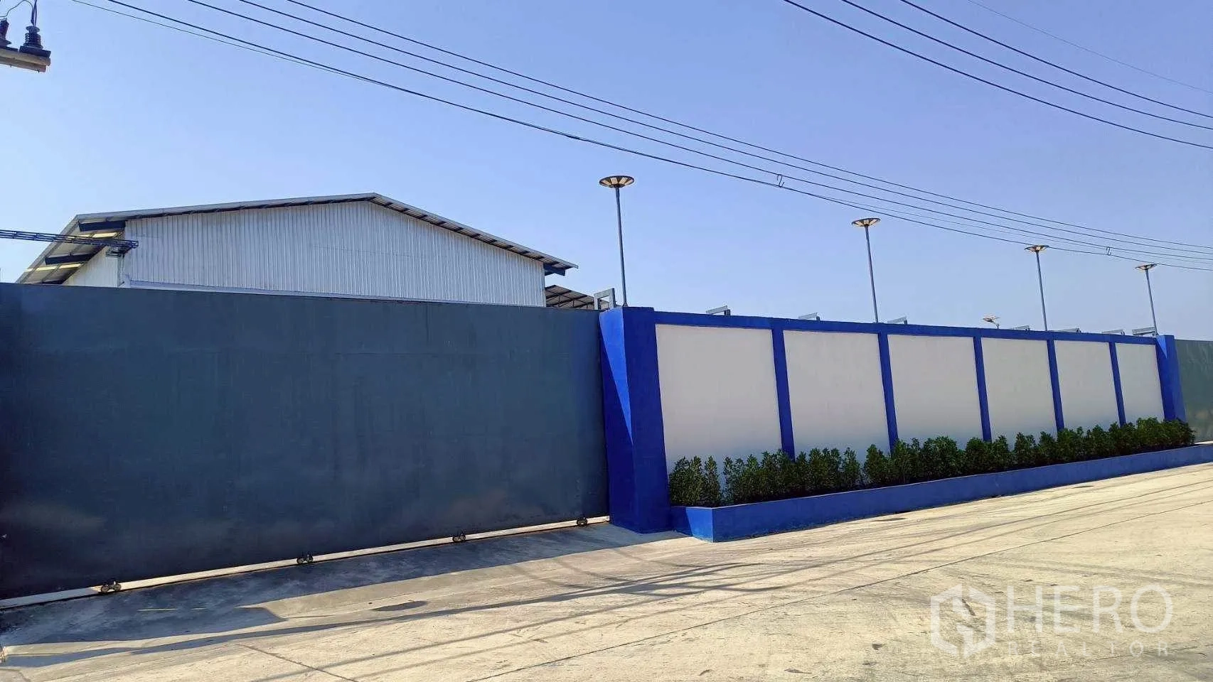 工厂 for rent or sale in Mueang Samut Sakhon, Samut Sakhon - 物业正面的巨大滑动钢门与围墙。