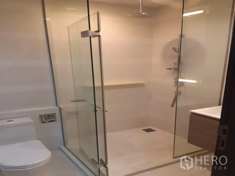Condominium for rent in Khlong Toei, Bangkok - Second bathroom featuring a rain shower in a frameless glass enclosure.