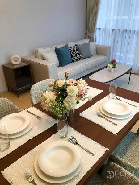 Condominium for rent - Table setting for four with floral centerpiece, sofa and coffee table behind.