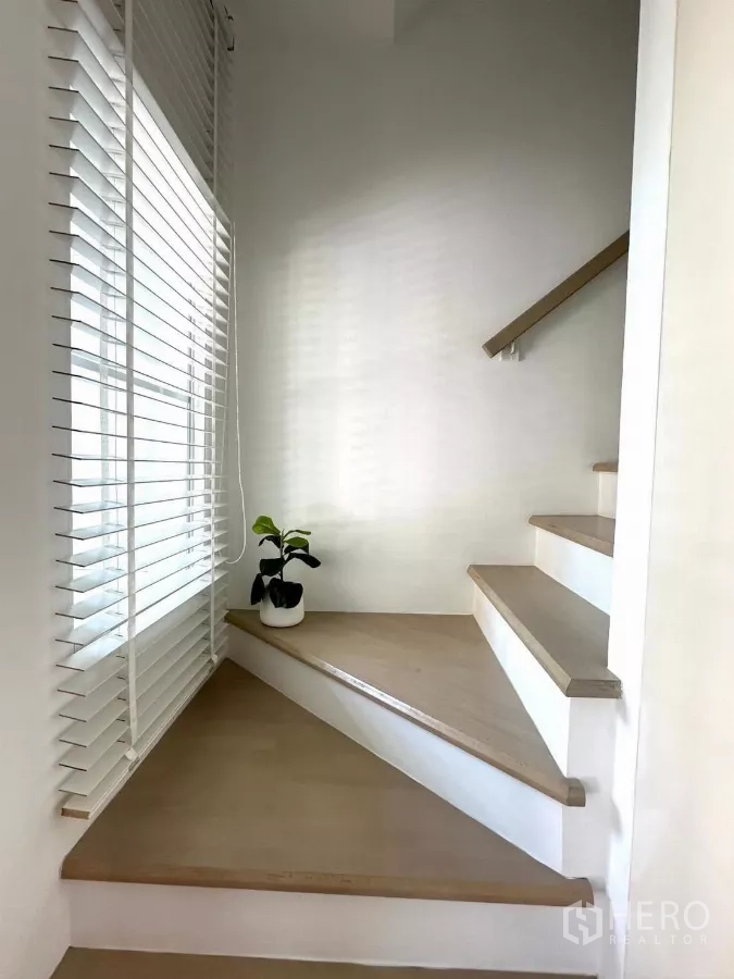 Townhouse for rent in Bang Phli, Samut Prakan - White staircase with wooden steps and window blinds.