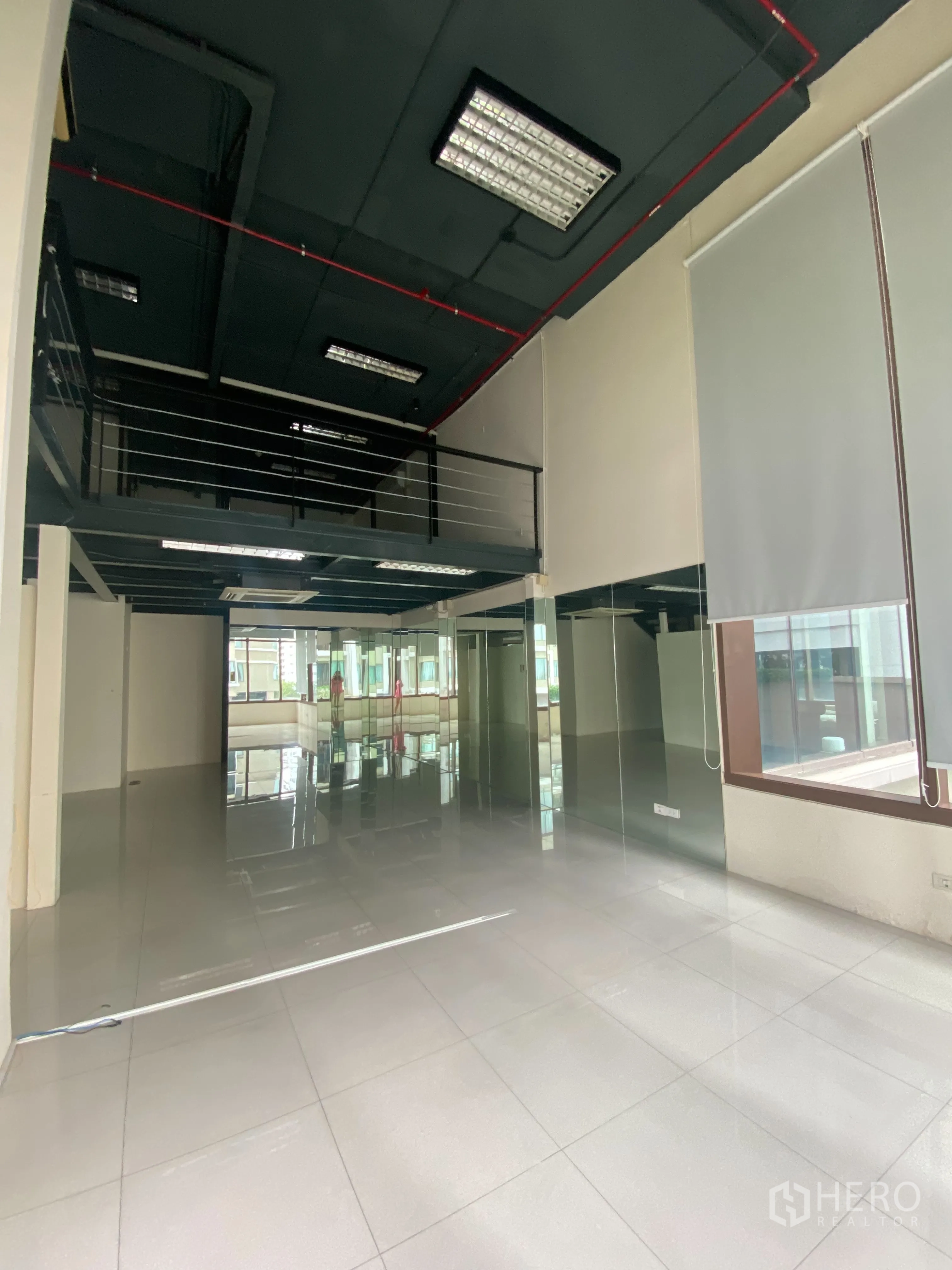 Office Space for rent in Khlong Toei, Bangkok - Double-height open-plan office with a mezzanine level, glossy floors, and large front windows.