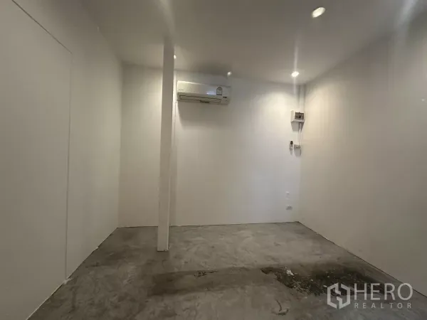 Retail Space for rent - Minimal retail space showing pillar, recessed ceiling lights, concrete floor and split-type air conditioner on the rear wall.