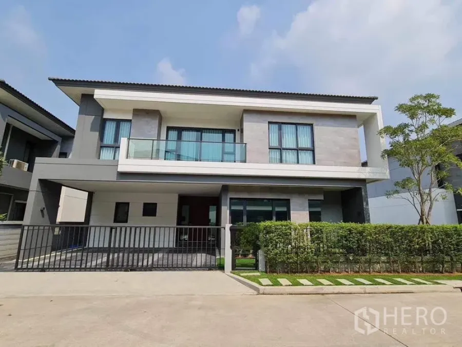 Detached House for rent or sale in Bang Phli, Samut Prakan - Modern two-storey detached house with balcony, carport and trimmed hedges in Bang Phli estate.