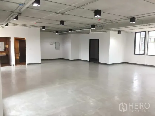办公空间 出租在Khlong Toei, Bangkok - 宽敞办公区域，水泥地、多扇窗户，带通往卫生间的门